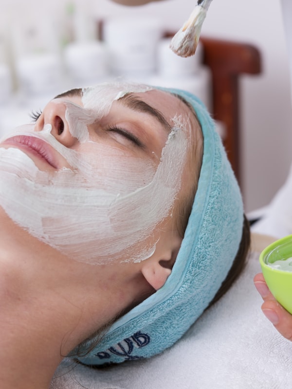 Client relaxing with a brightening facial mask at Lumière